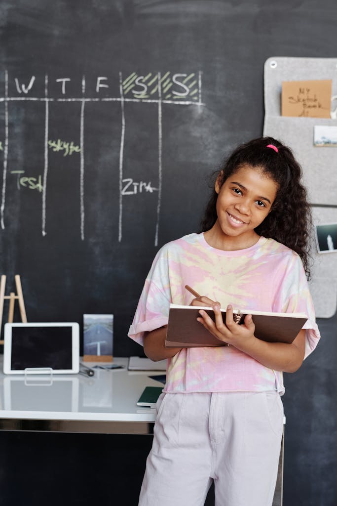 Girl in Pink and White Crew Neck T-shirt Holding Brown Notebook