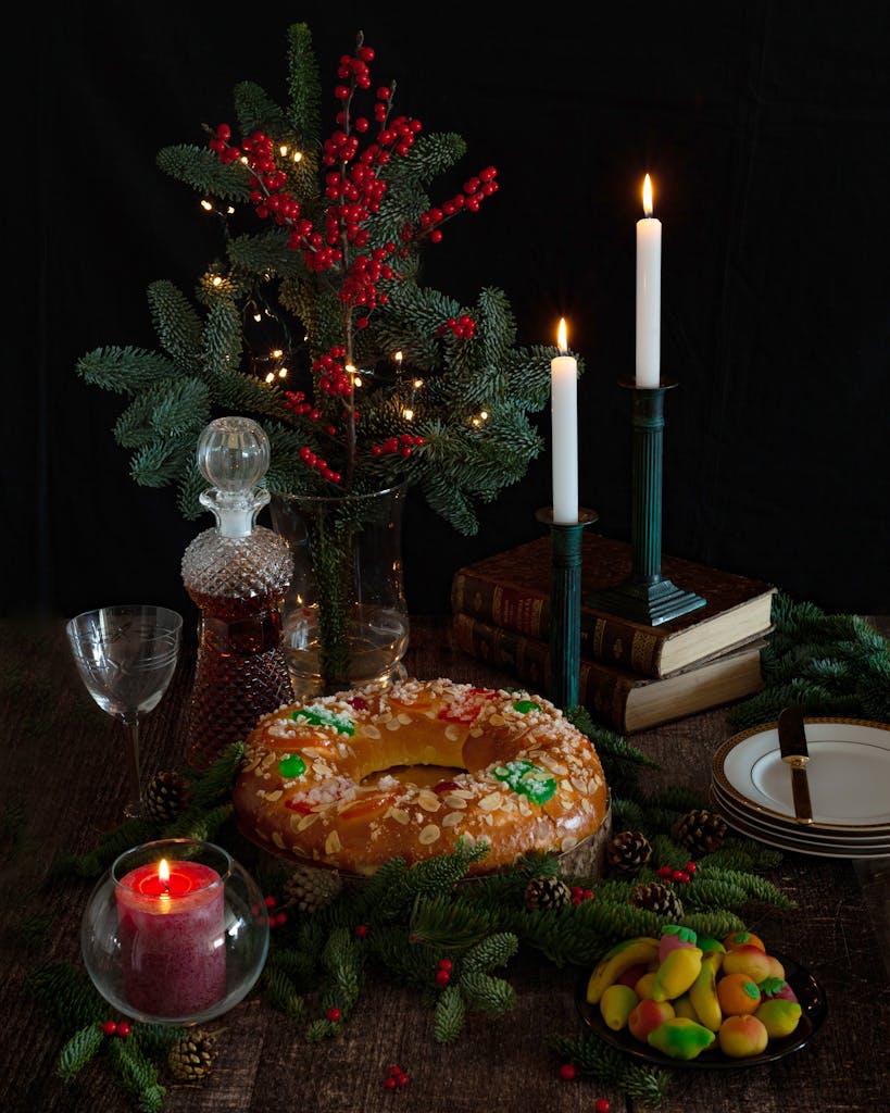 Elegant Christmas setting with candles, holiday decor, and festive treats in a cozy atmosphere.